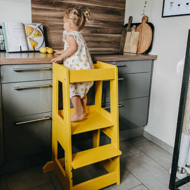 Beuken houten tiSsi® leertoren FELIX in zonnebloemgeel. Ideaal voor kinderen om zelfstandig te leren staan, klimmen en ontdekken in de keuken of woonkamer.